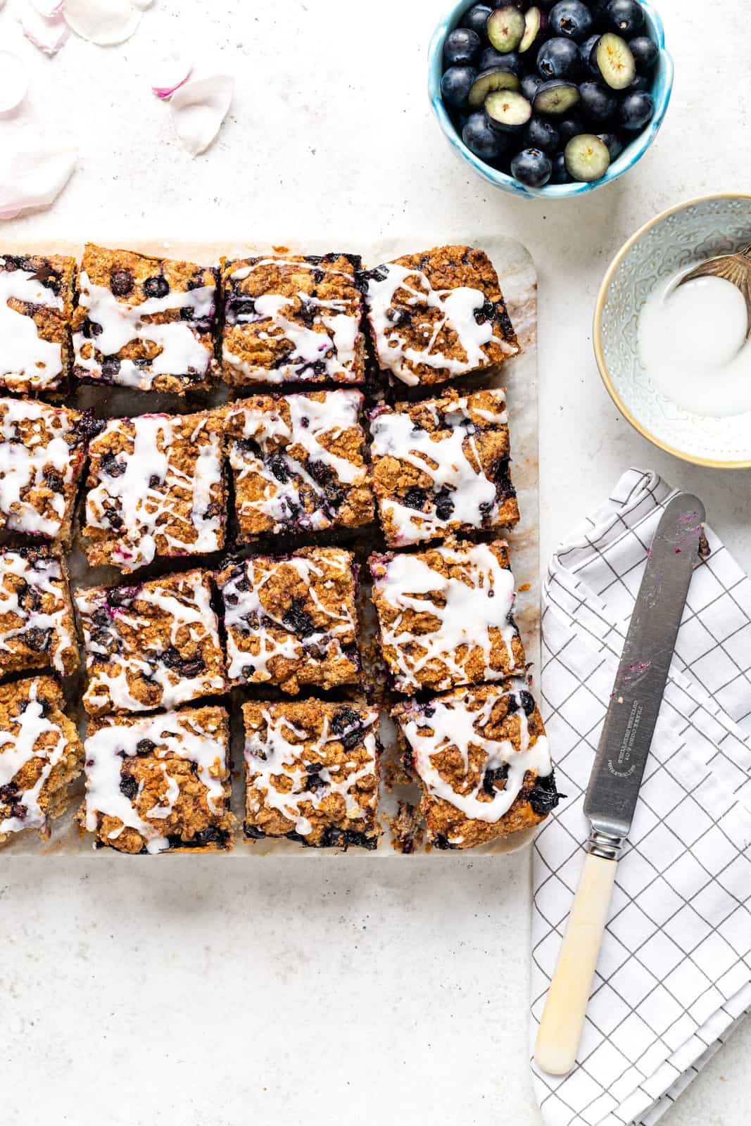 Blueberry crumb cake cut into squares on a marble board