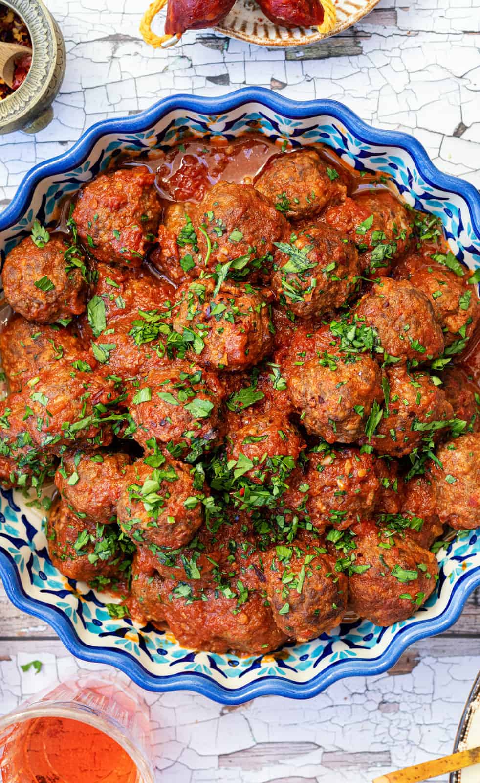 close up on a bowl of Spanish meatballs garnished with chopped parsley