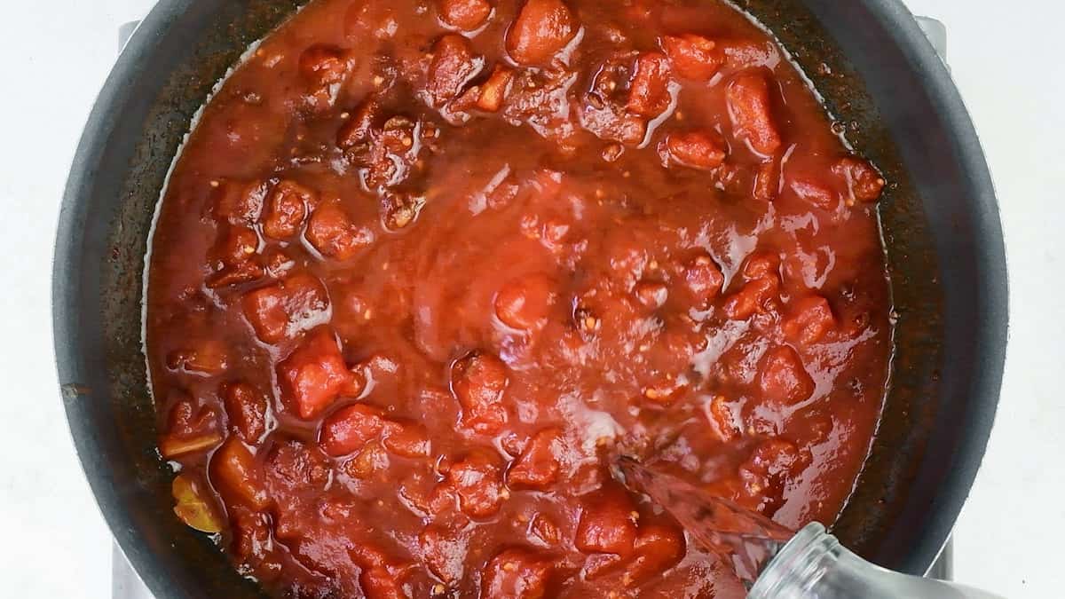 making tomato sauce for Spanish meatballs in a chef's pan