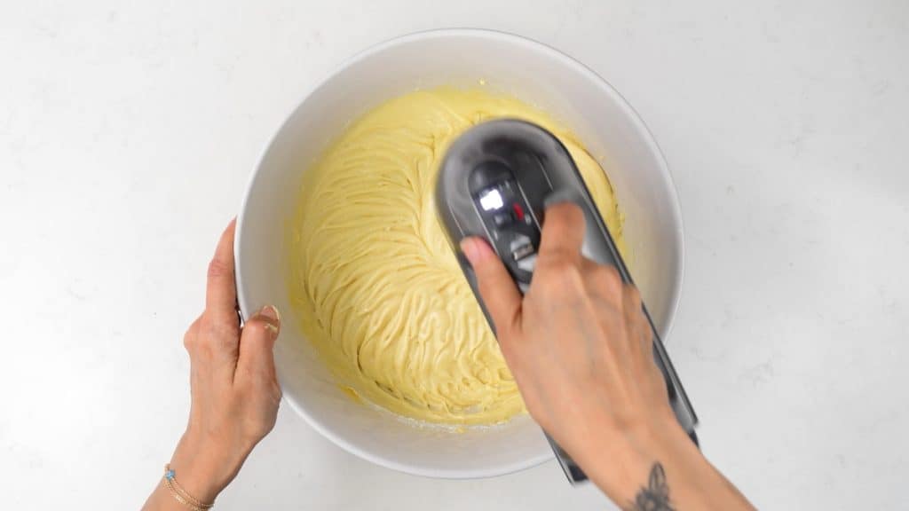 Beating cake batter in a mixing bowl with a hand mixer