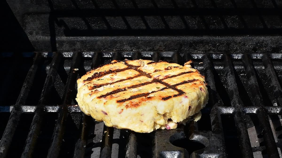 grilling a large turkey burger on the barbecue