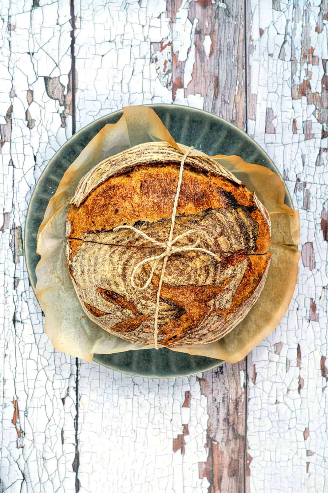 Overhead view of easy overnight sourdough bread tied with string on a plate