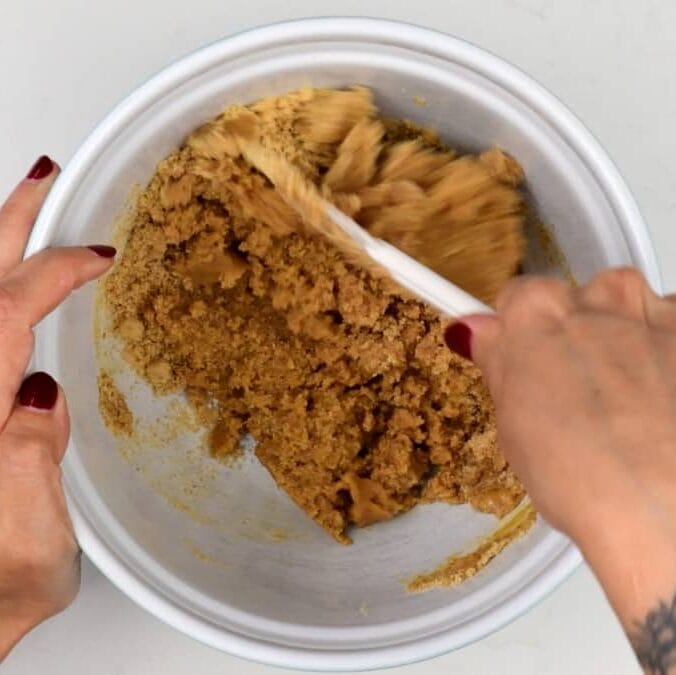 mixing graham cracker crumbs with melted butter to make crust