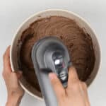 beating chocolate cake batter with an electric hand mixer