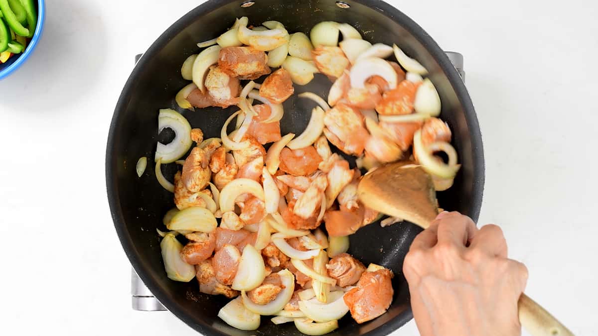 pan frying chicken and onions with fajita seasoning