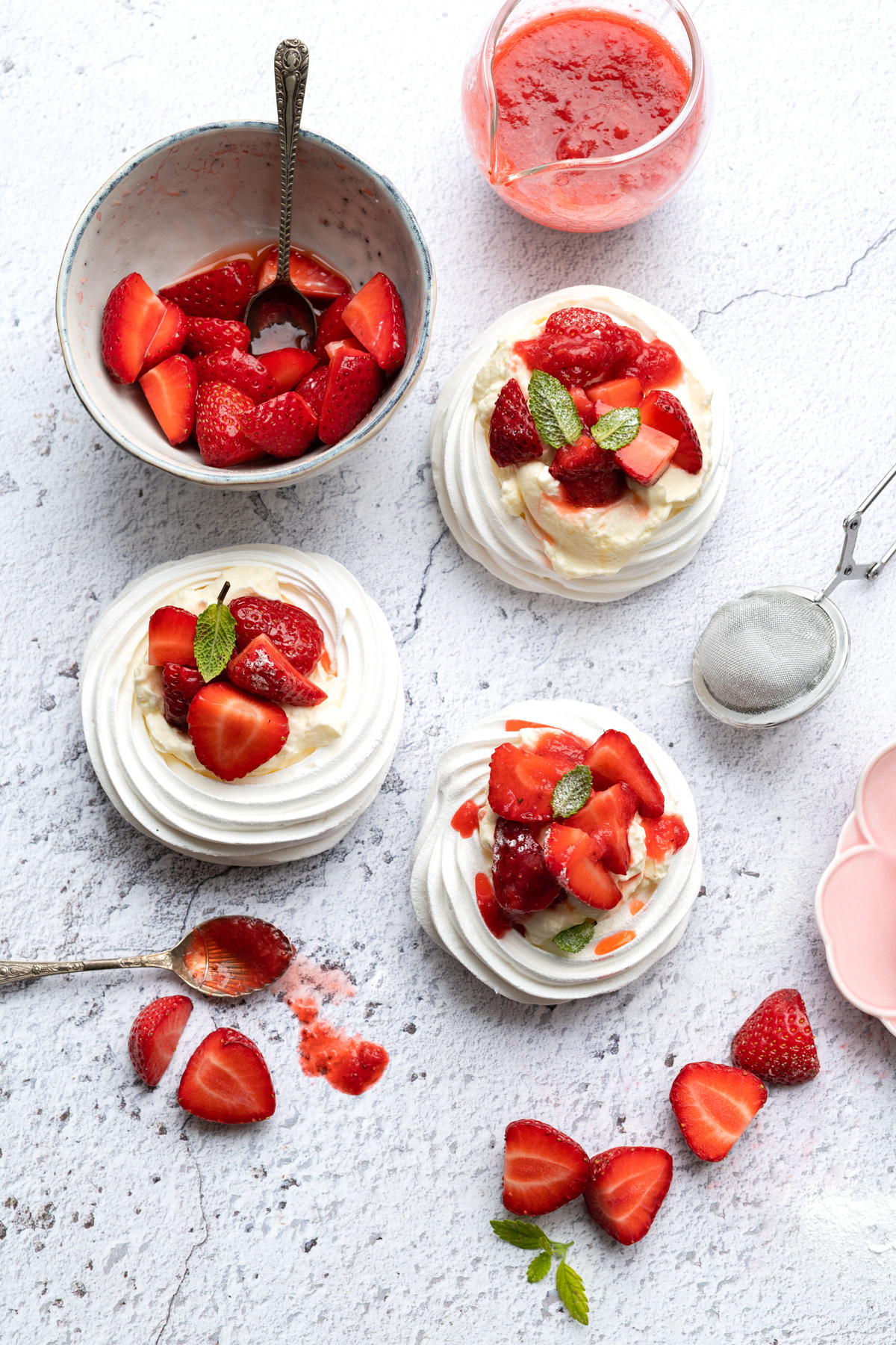meringue nests filled with whipped cream and strawberries to make mini pavlovas