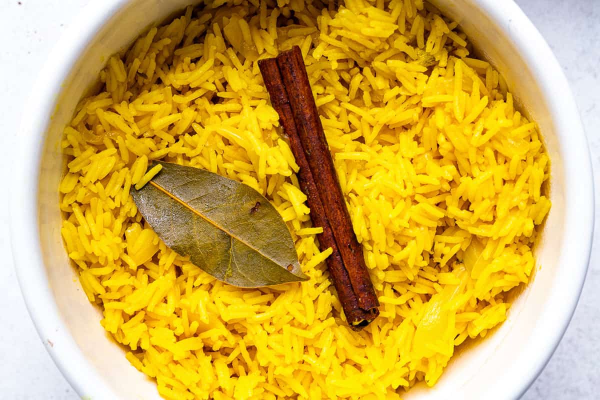 Golden pilau rice in a white pot close up