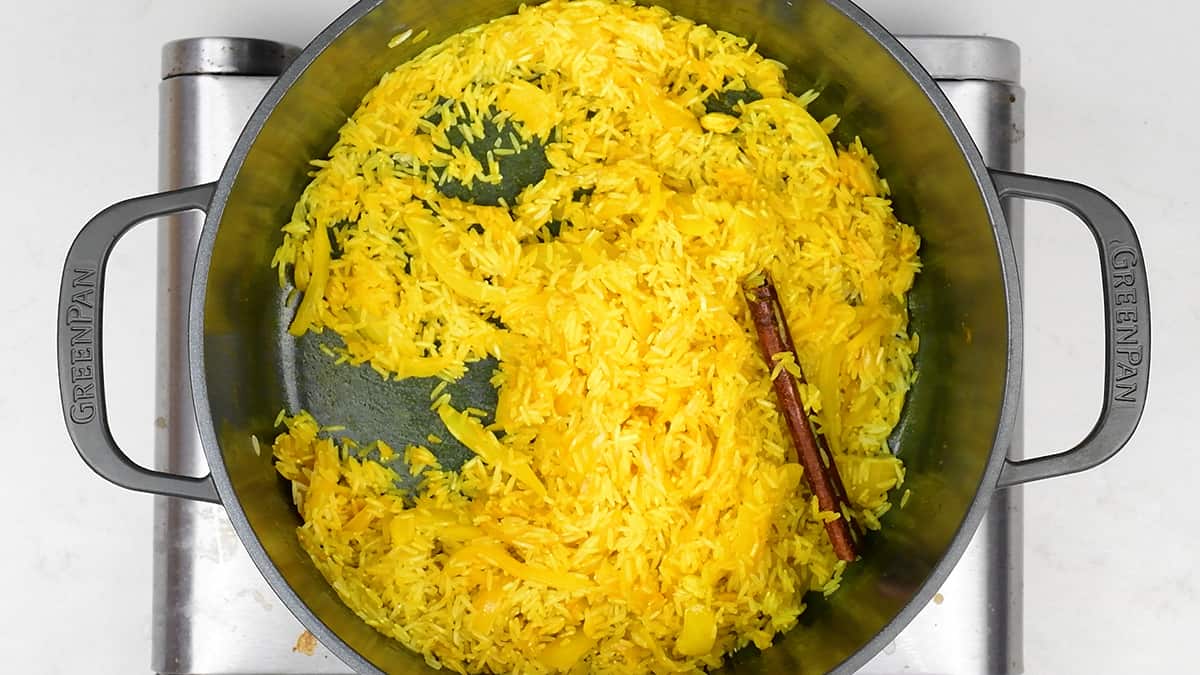 Coating basmati rice in spiced butter and onion in a pot
