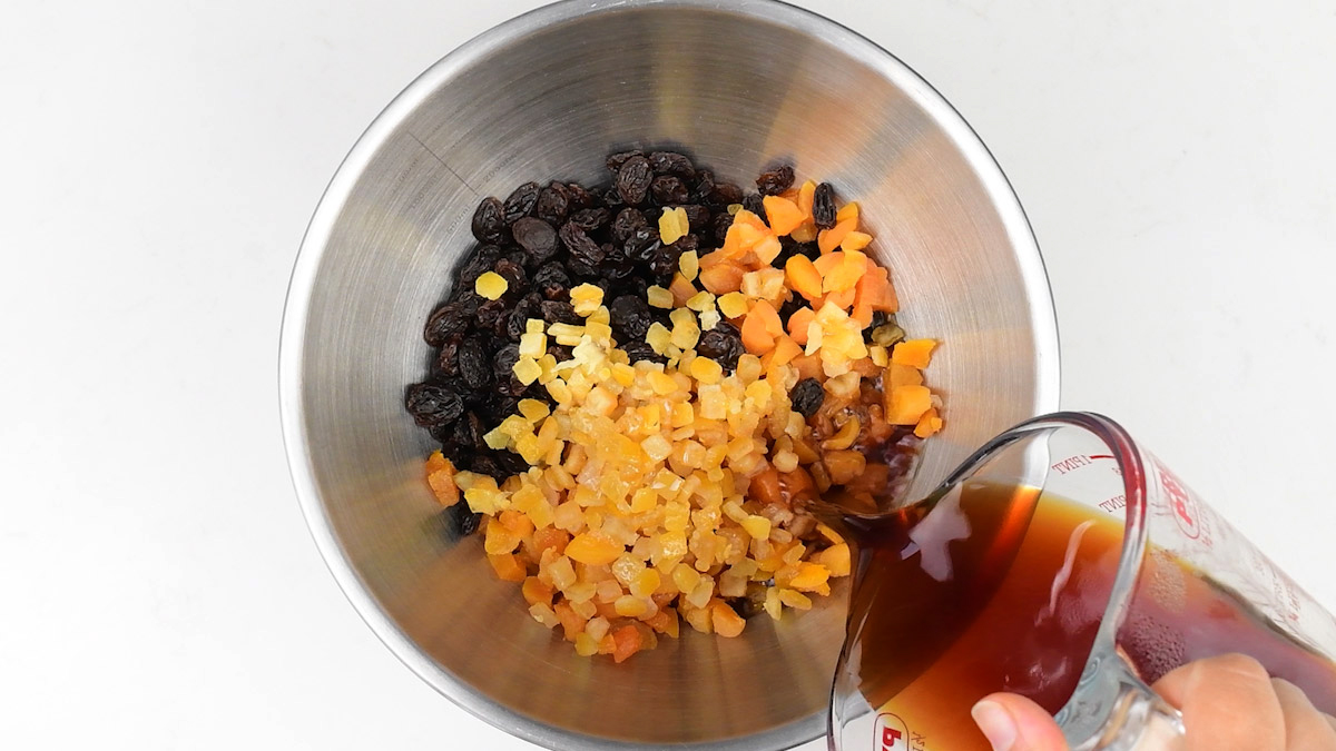adding tea to a bowl of mixed dried fruit