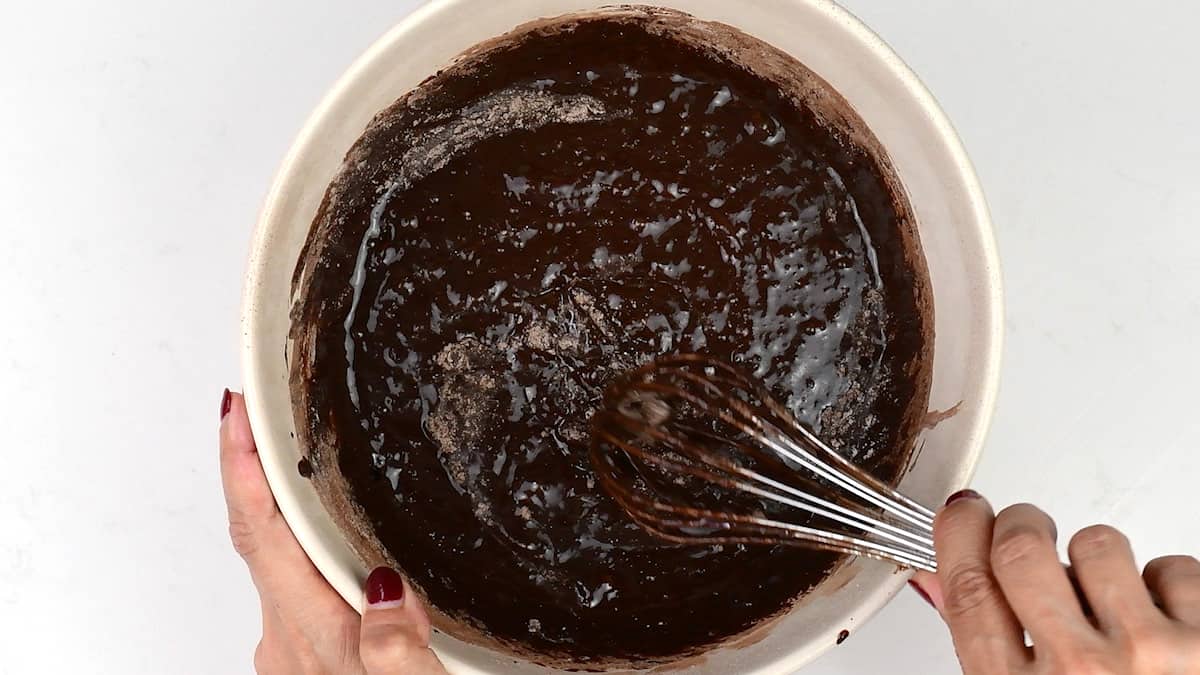 stirring brownie batter in a bowl