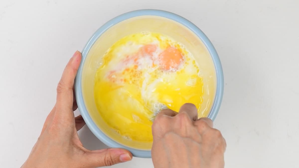 beating eggs, melted butter and milk in a bowl
