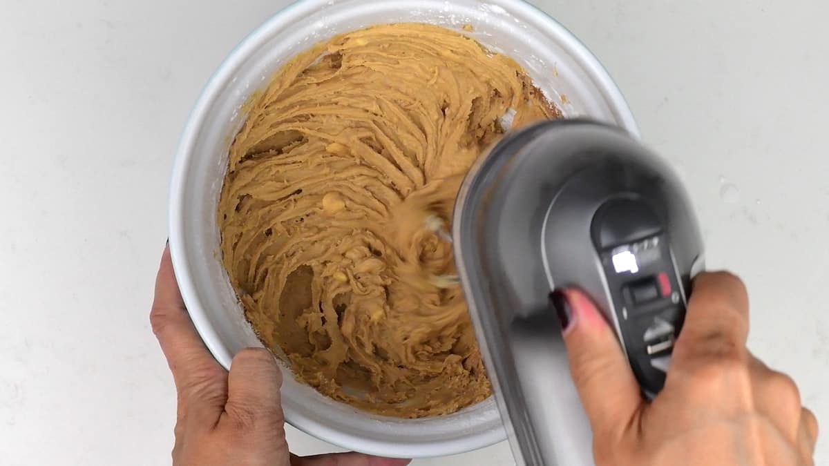 beating ingredients for Biscoff frosting in a bowl