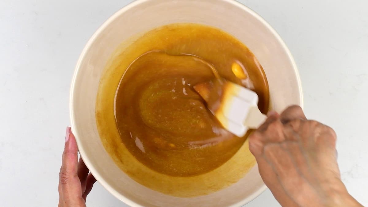 stirring melted butter and Biscoff spread in a bowl