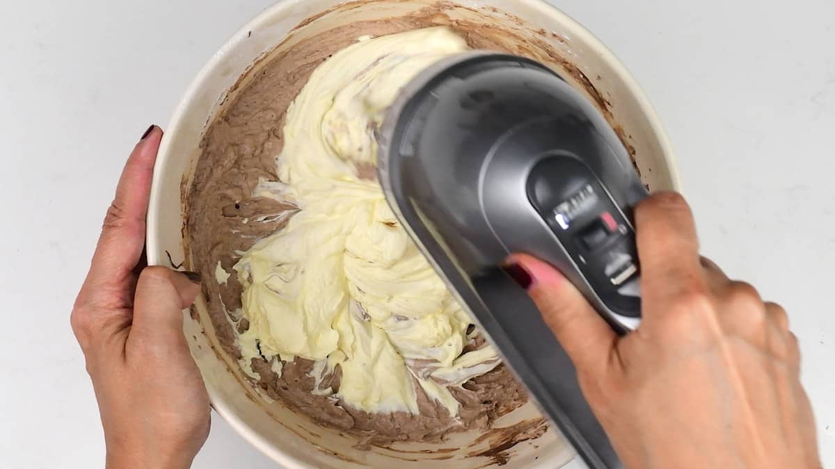 Beating whipped cream into cheesecake filling