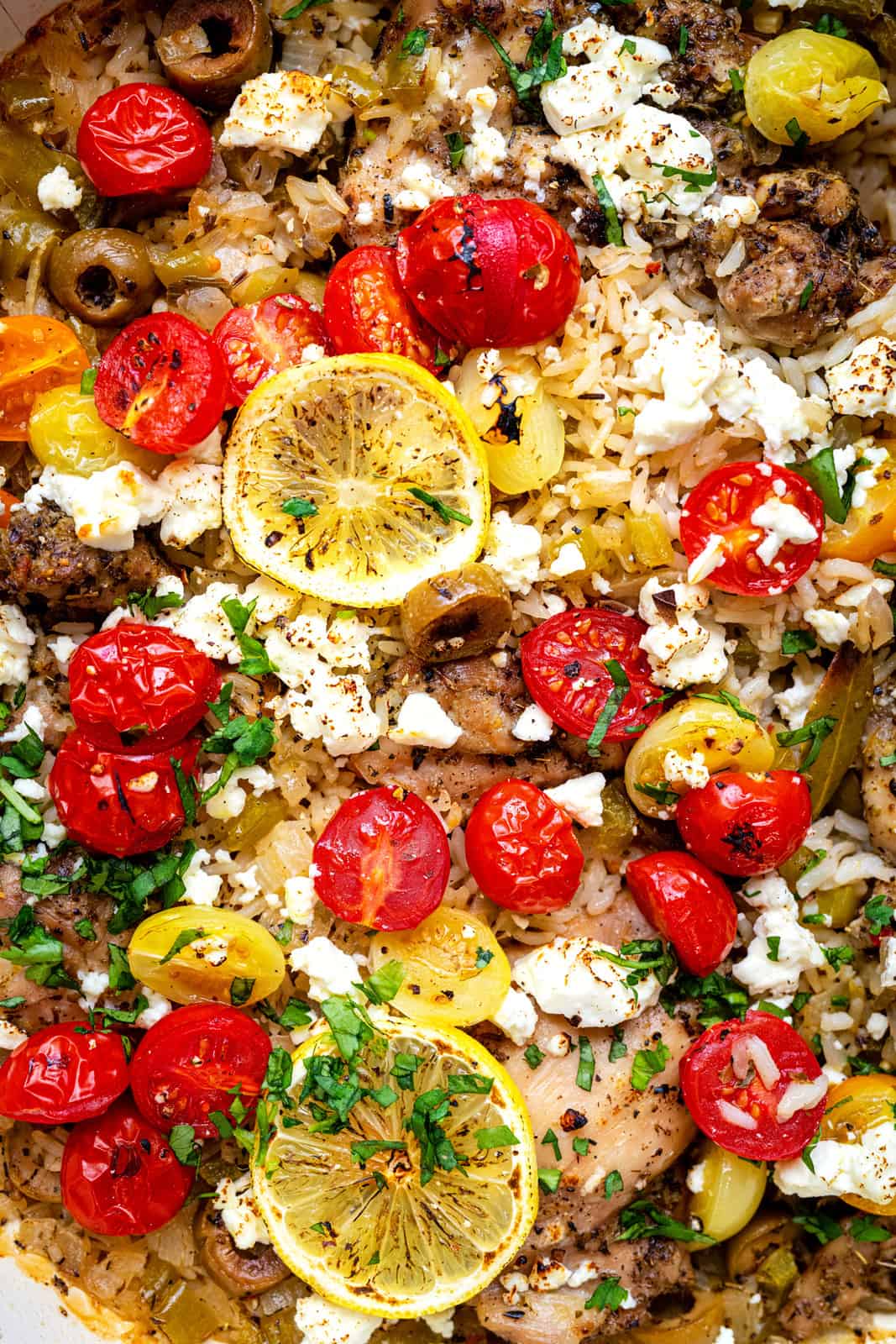 close up on Greek chicken and rice dish with cherry tomatoes and feta cheese