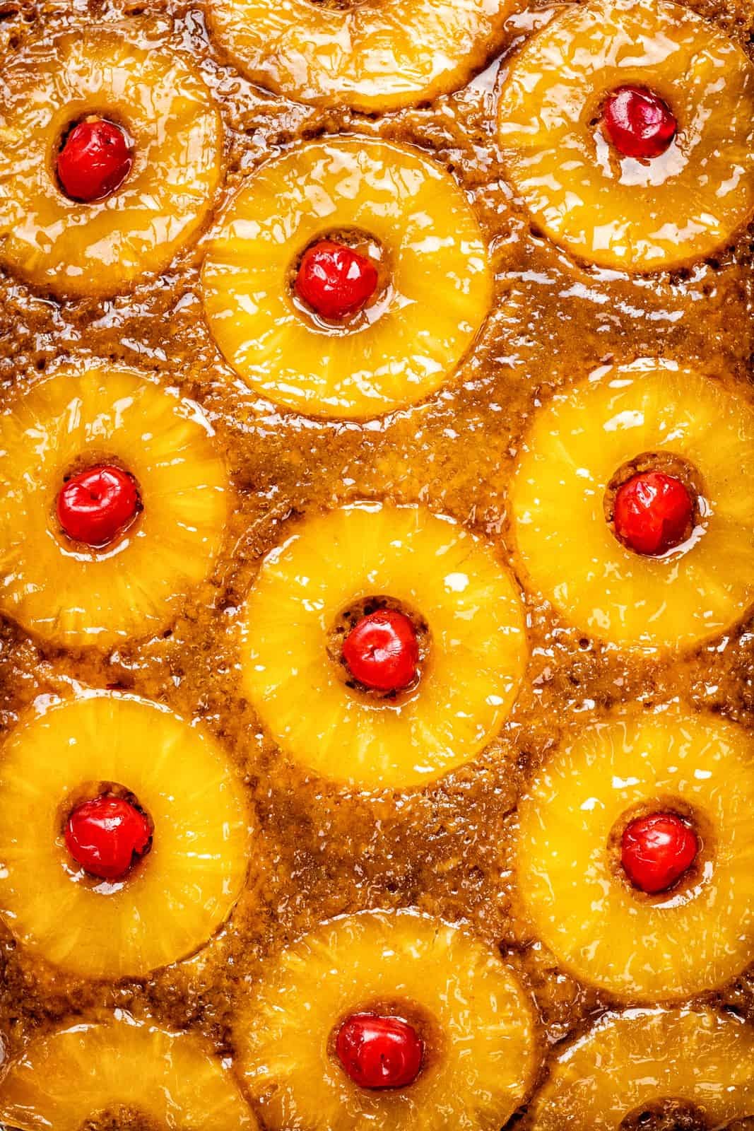 Close up on a pineapple upside down cake brushed with apricot glaze