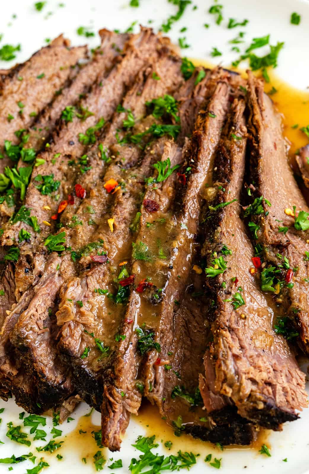 close up on sliced keto beef brisket served with gravy and garnished with parsley
