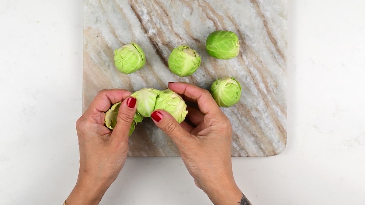 Removing outer leaves from Brussels sprouts