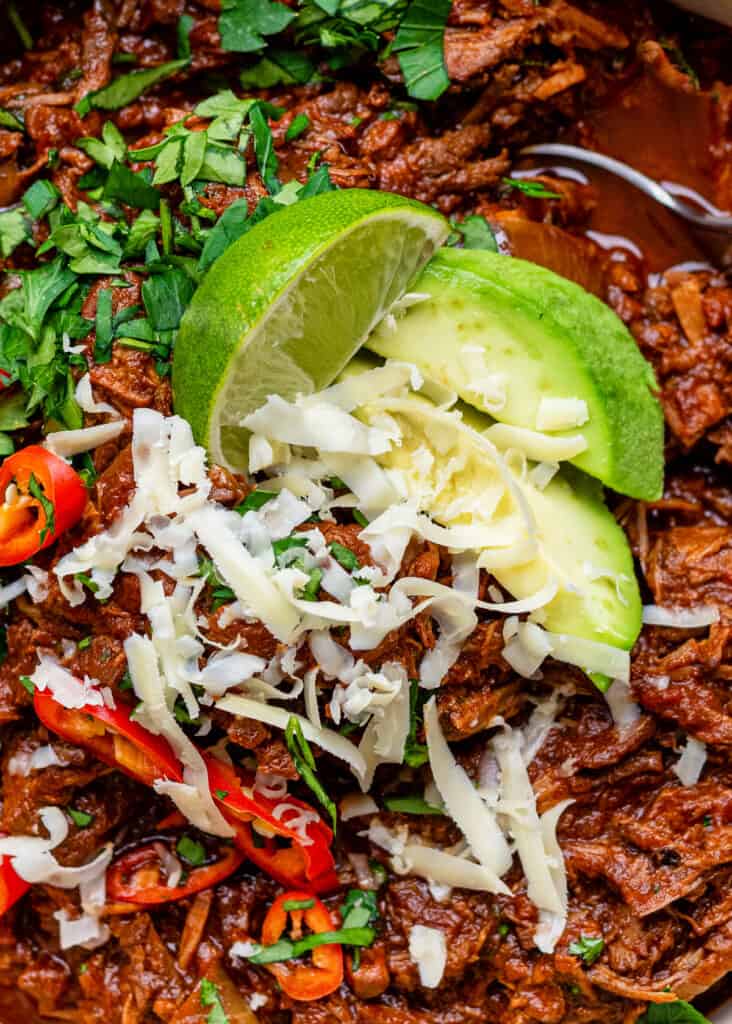 close up on low carb keto chili with avocado and cheese topping