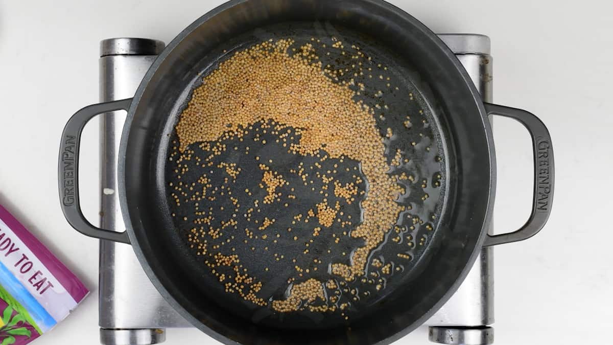 pan frying mustard seeds in a pot