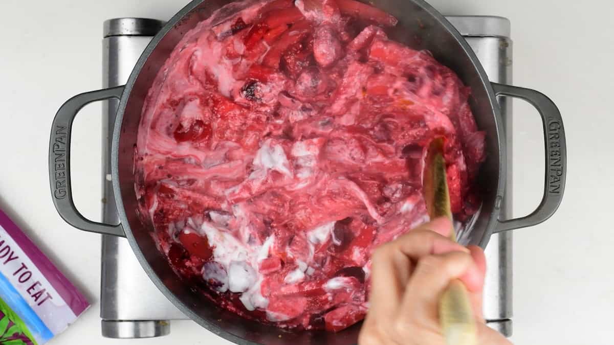 stirring coconut milk into beetroot curry