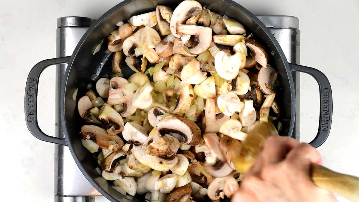 Cooking mushrooms and onions in a pot