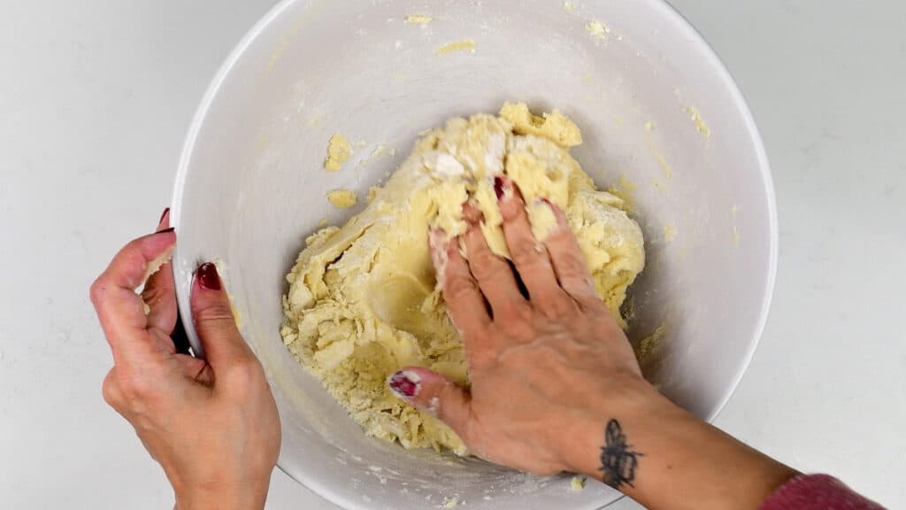 Kneading sugar cookie dough in a bowl