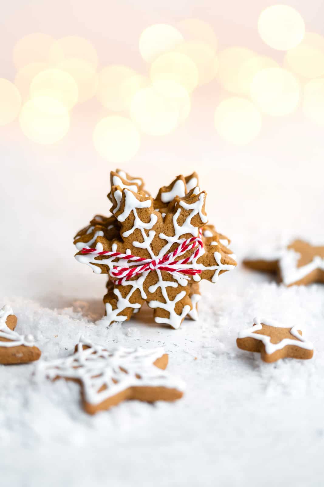 Vegan gingerbread cookies shaped like snowflakes with white icing decoration 