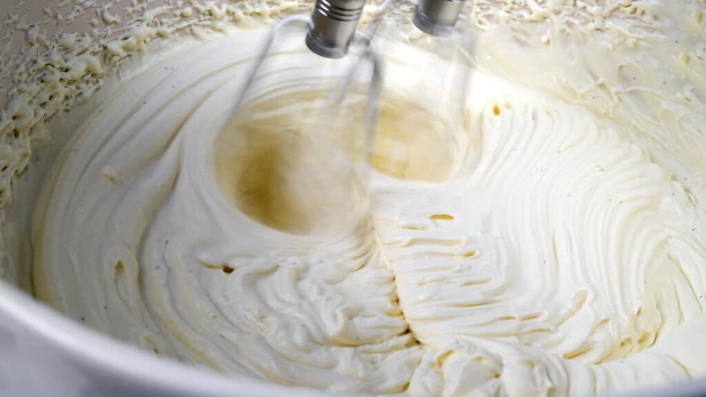 Close up on  creamy frosting being whipped in a bowl
