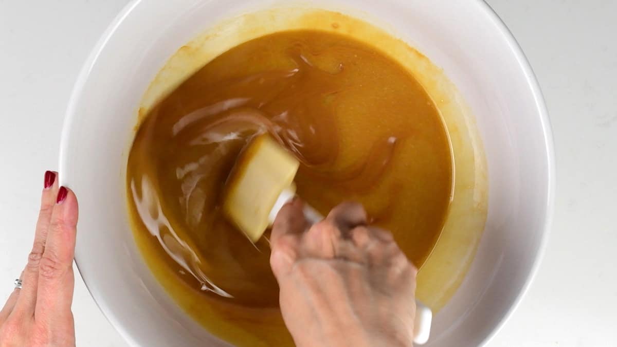 mixing together melted butter and Biscoff spread in a bowl