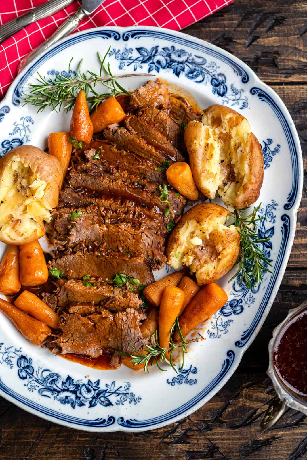 platter with sliced beef brisket, gravy, potatoes and carrots