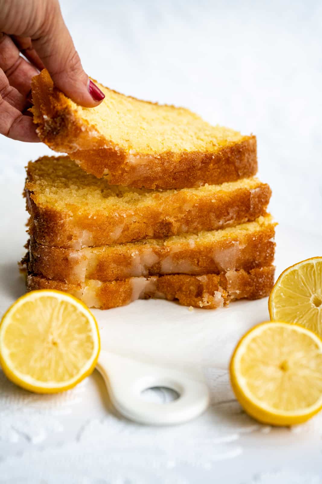 Lemon drizzle cake slices stacked on a ceramic board