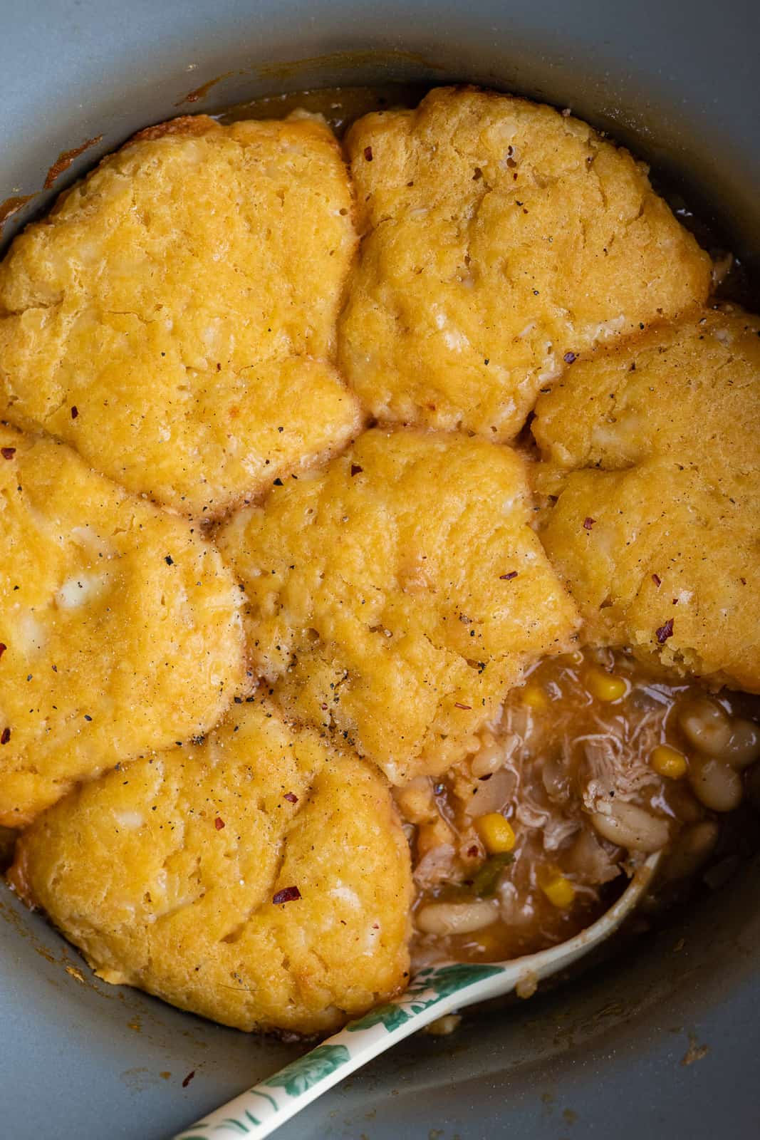 close up on crockpot chicken Chili With Cornbread dumplings with one dumpling taken out to reveal the chili