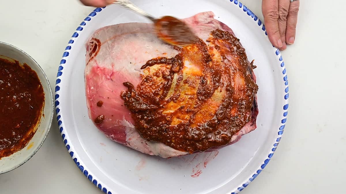 Covering shoulder of lamb with marinade