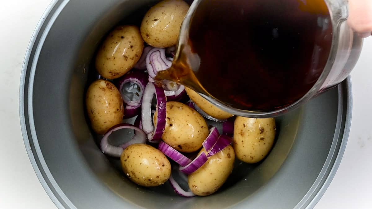 Potatoes, onions and stock in a slow cooker