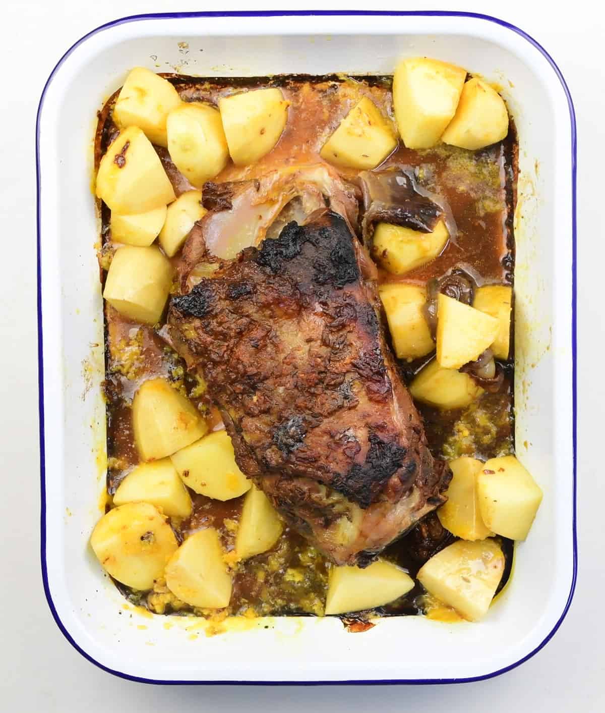 Spiced lamb shoulder in a roasting tin with chopped potatoes