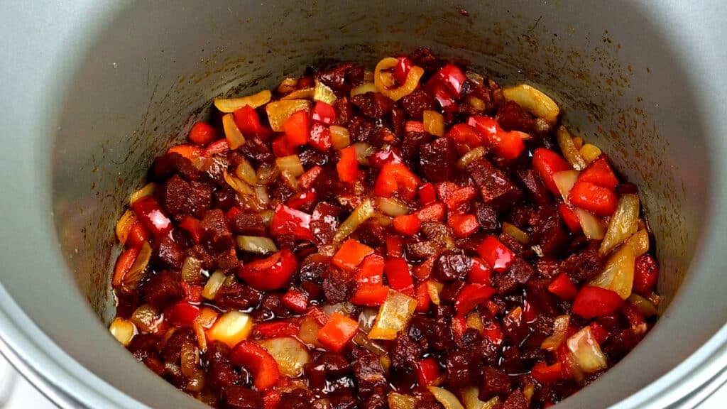 Chorizo, onions and red pepper cooking in a slow cooker