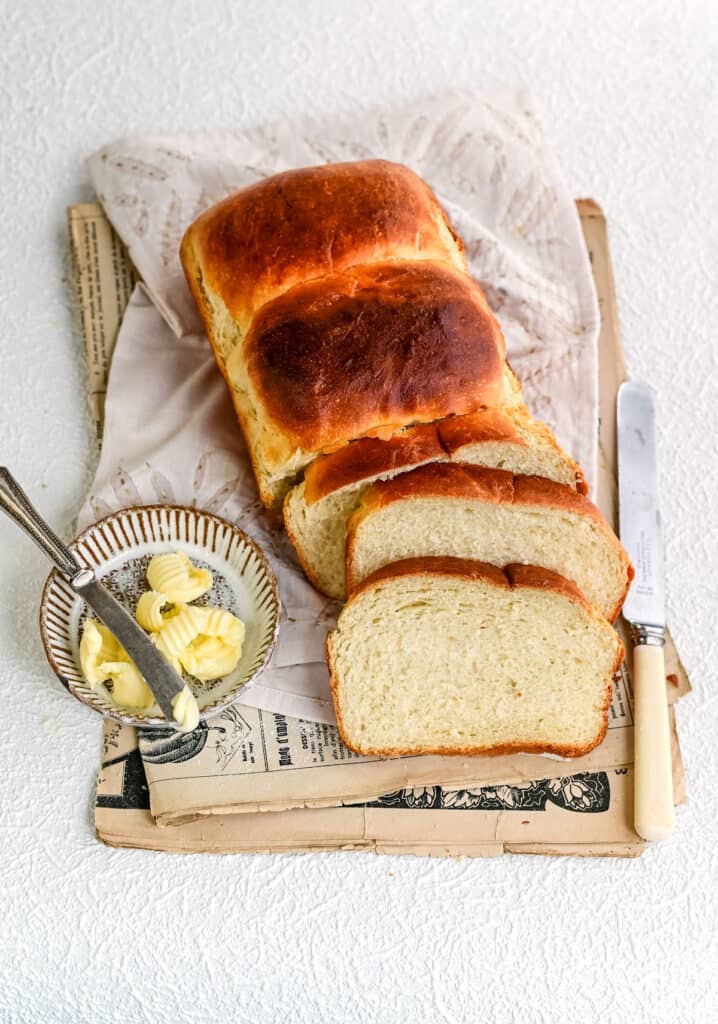 sliced japanese milk bread loaf with butter on the side