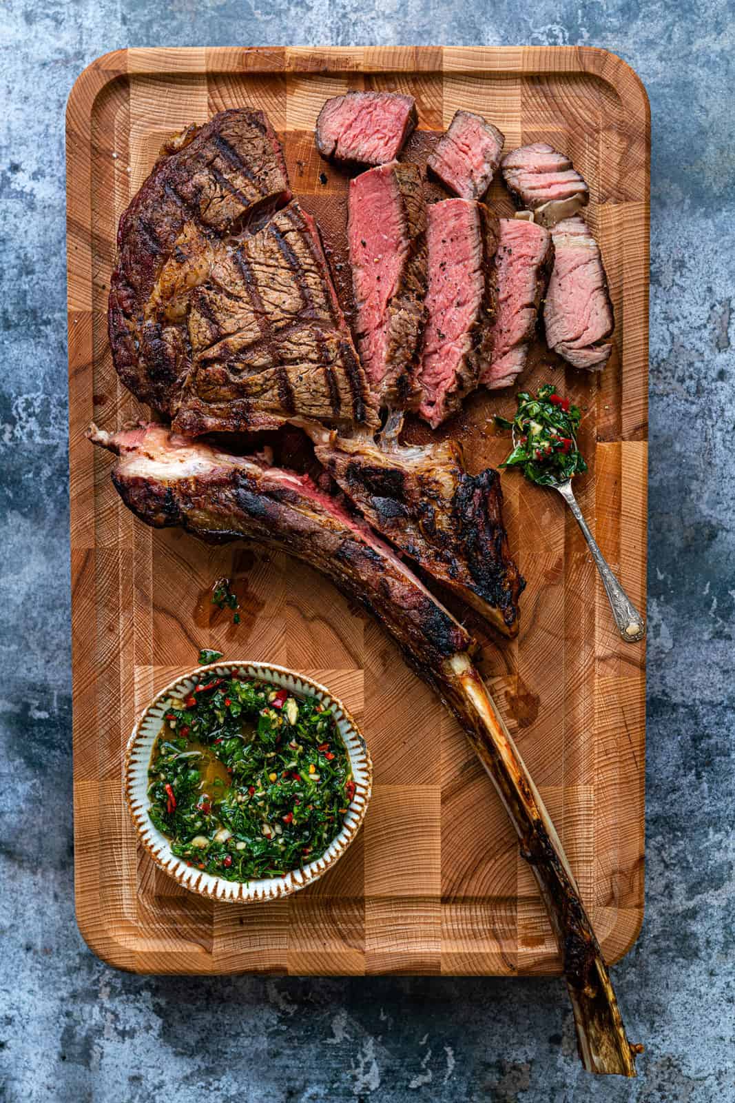 reverse sear steak sliced on a wooden board