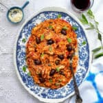 Greek chicken and orzo pasta on a blue platter