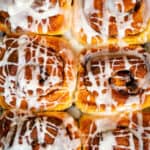 close up of sourdough cinnamon rolls drizzled with glaze