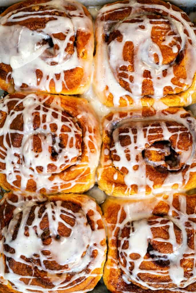 close up of sourdough cinnamon rolls drizzled with glaze