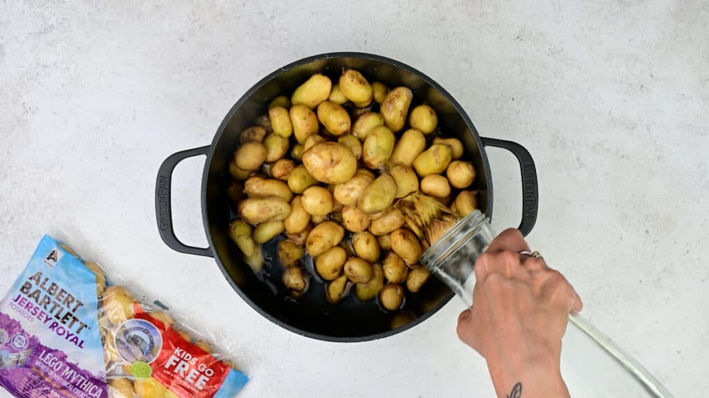 Jersey Royal potatoes in a pot water being added