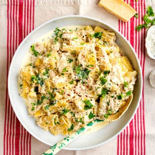 crockpot creamy chicken pasta with parmesan and cream cheese in a large bowl