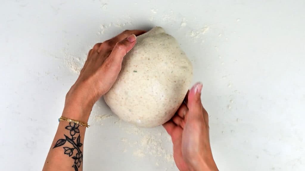 shaping sourdough into a boule