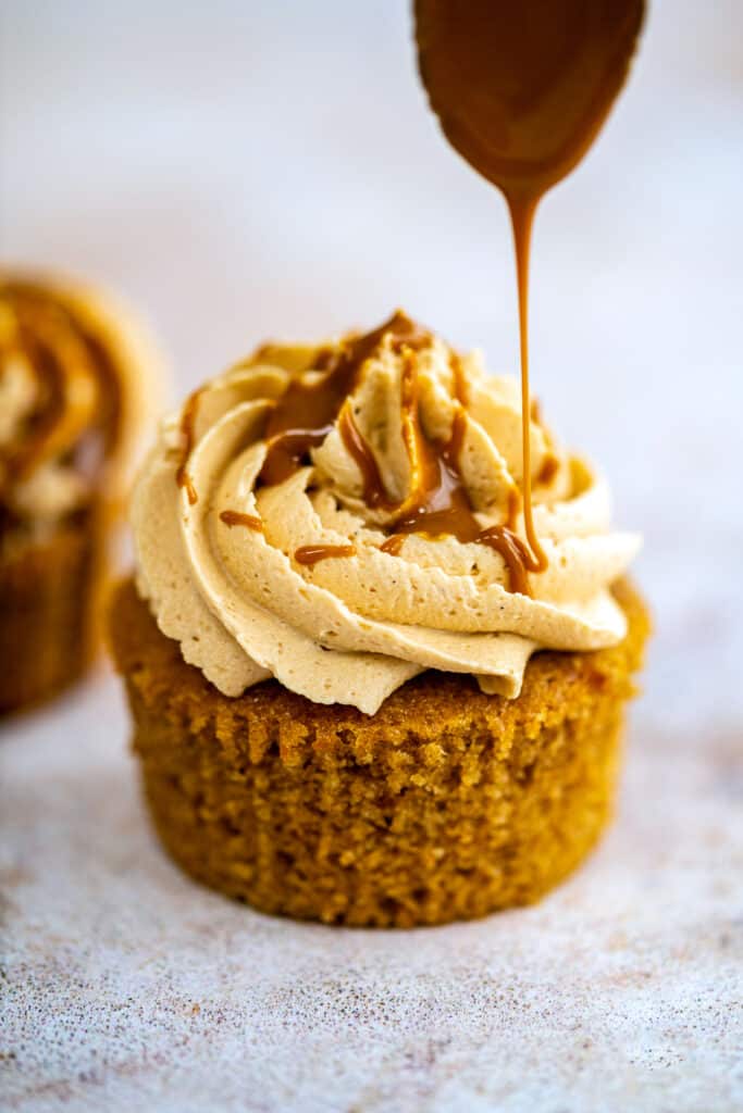 drizzling Lotus Biscoff spread over a cookie butter cupcake