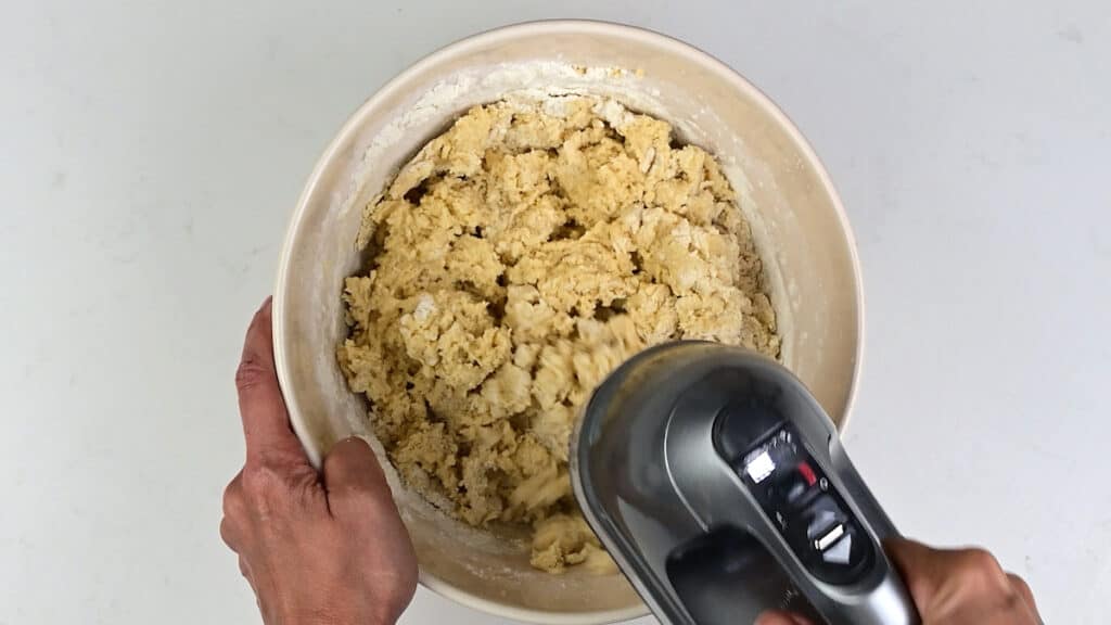 Beating flour into cherry pie bar crust in a bowl