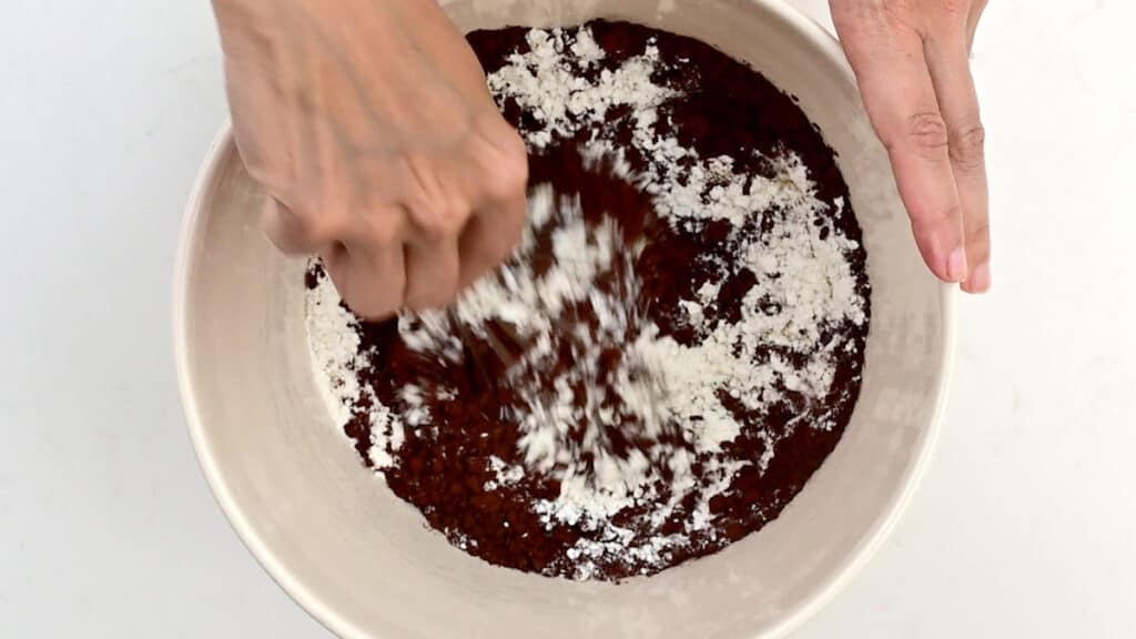 stirring the dry ingredients for chocolate cake in a mixing bowl
