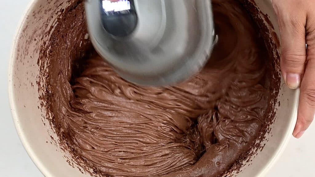 Beating batter for chocolate loaf cake using an hand mixer