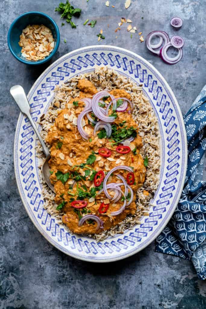 Creamy mild lamb curry served on a bed of rice with coriander, onion and chilli garnish
